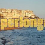 Giocatore felice con una ricevuta del Superenalotto che mostra il numero 6 vincente.