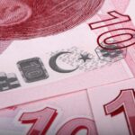 Banconota in primo piano con data di dismissione, simbolo di cambiamenti nei pagamenti.